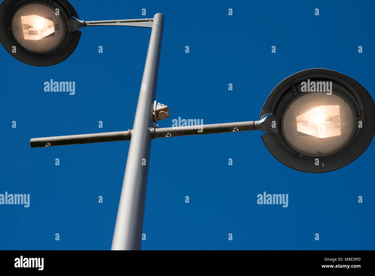looking up at a street lamp during day light with blue skies Stock Photo