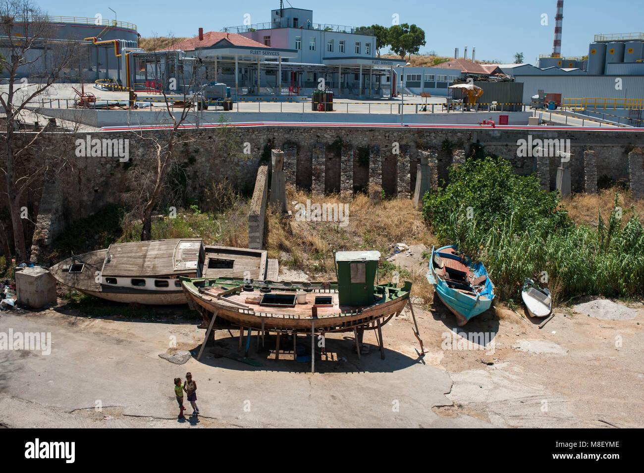 Piraeus. Gypsy girls play around abandoned boats. Greece. Stock Photo