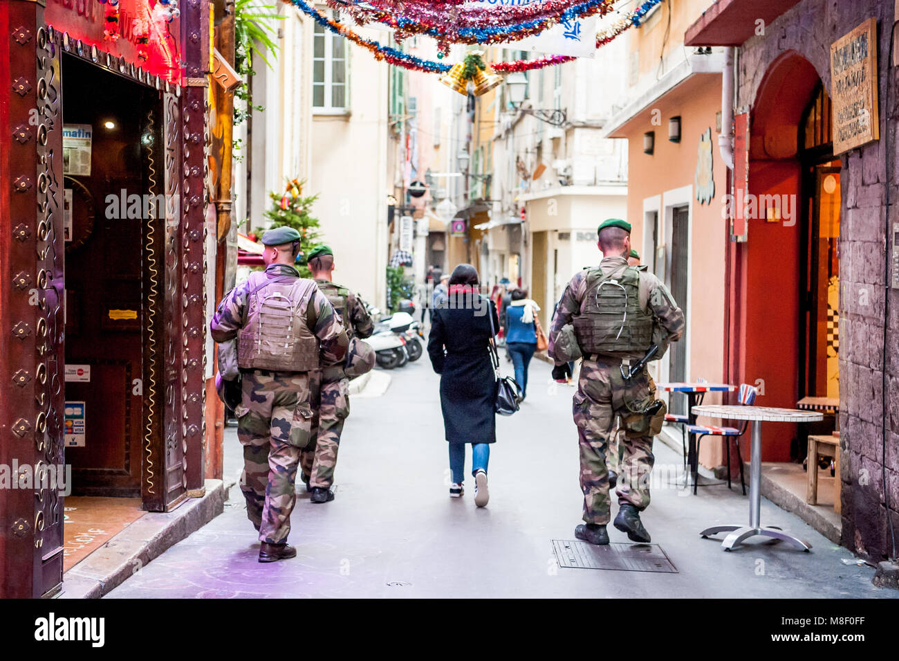 Armed soldiers walk through the old town district of Nice, France offering protection to locals and tourists in light of increased terrorist threats. Stock Photo