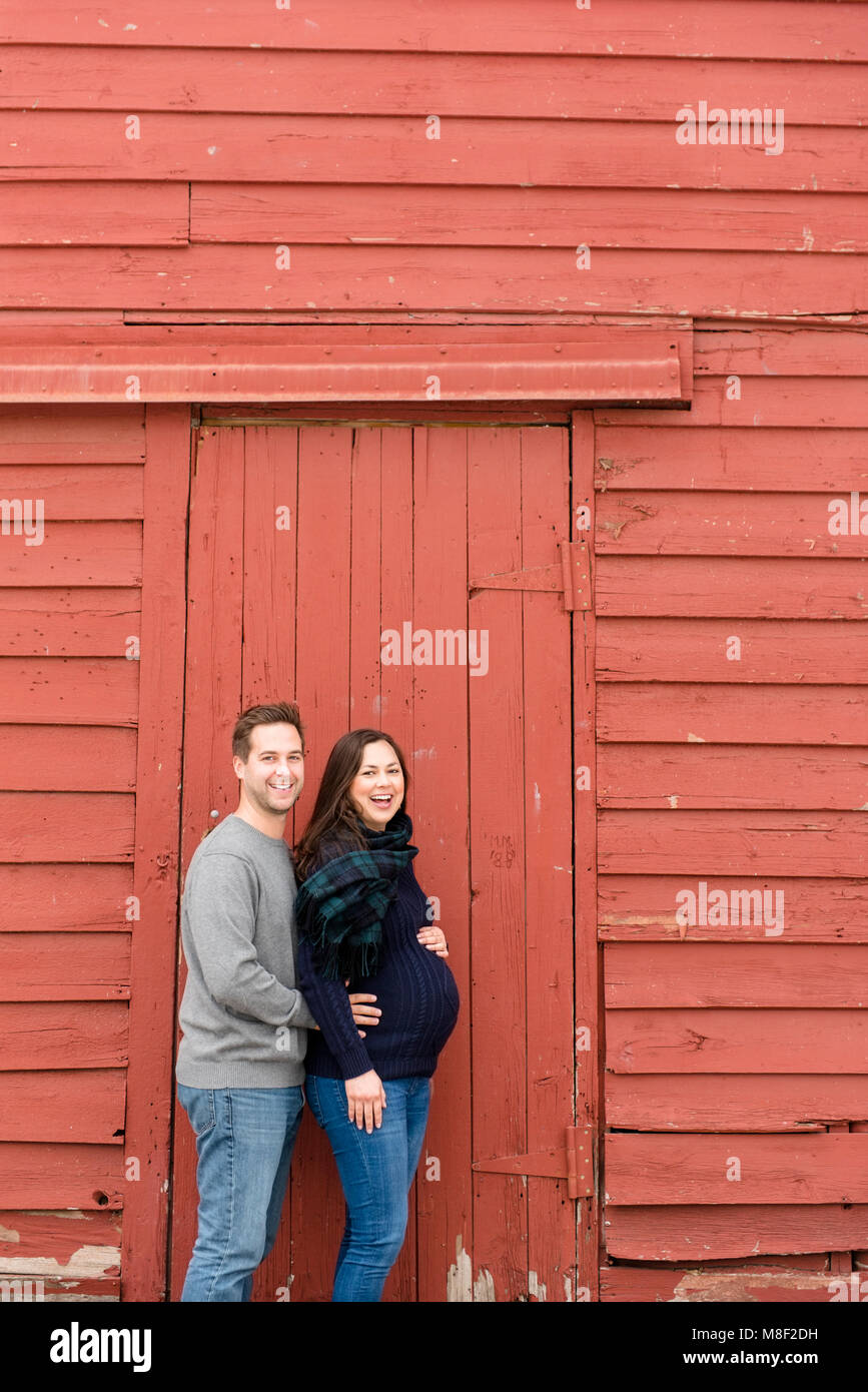 Mid adult couple standing in front of red barn Stock Photo - Alamy