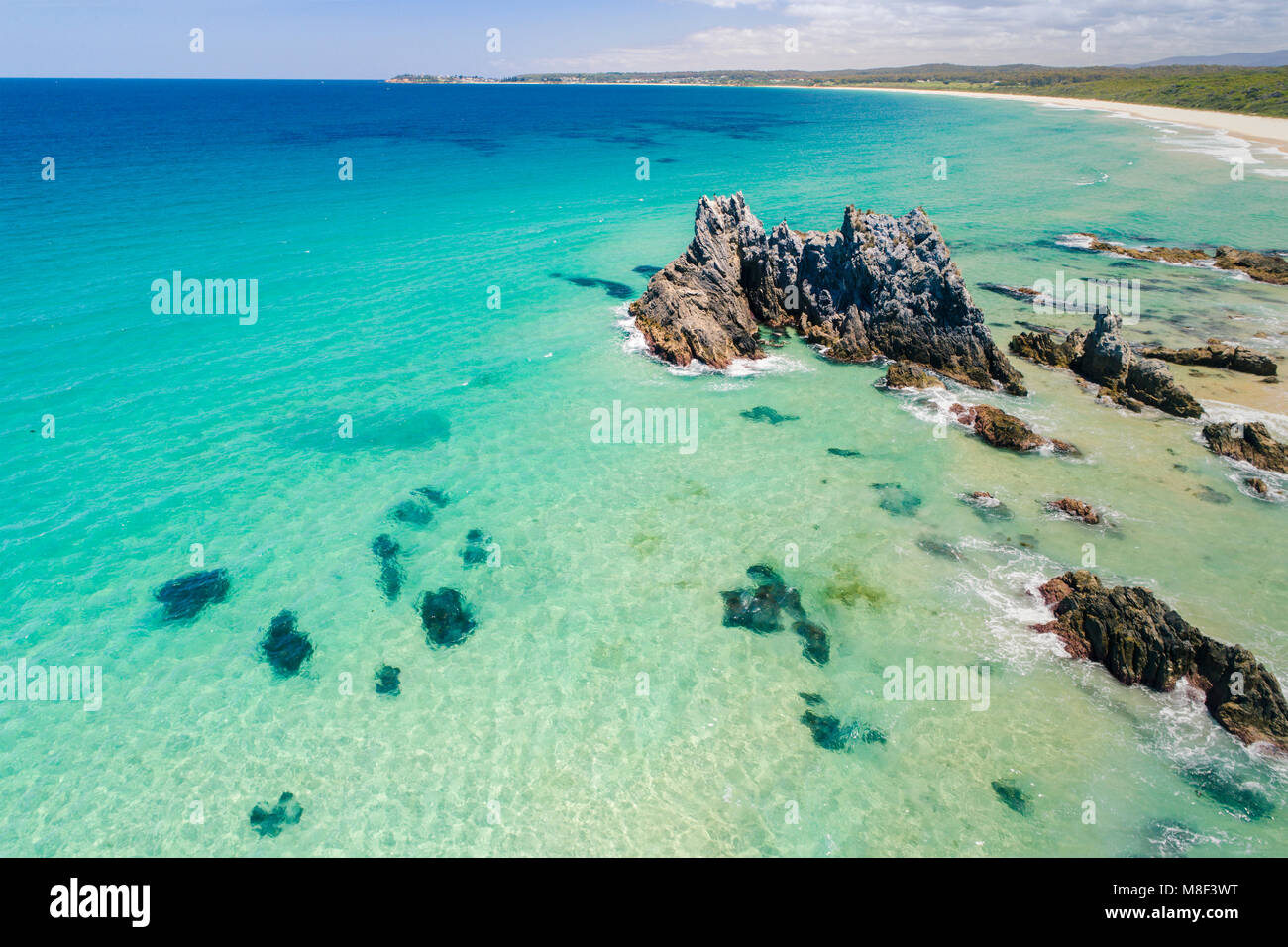 Australia, New South Wales, Bermagui, Turquoise sea with rock formation and coastline in background Stock Photo