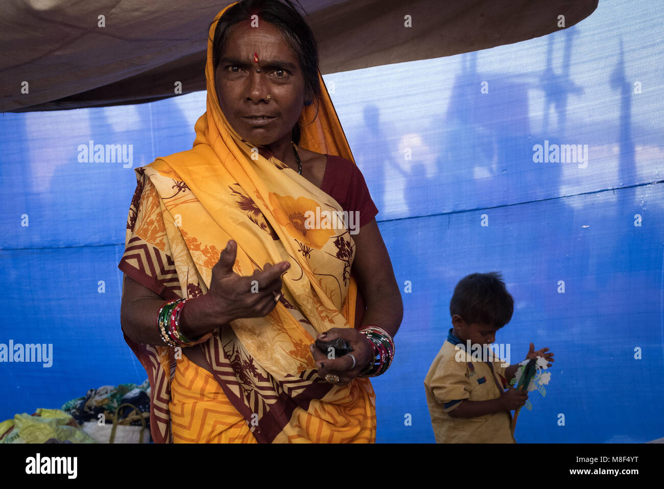 A woman staring in bemusement as her child plays in the background in Sonepur, India. Stock Photo