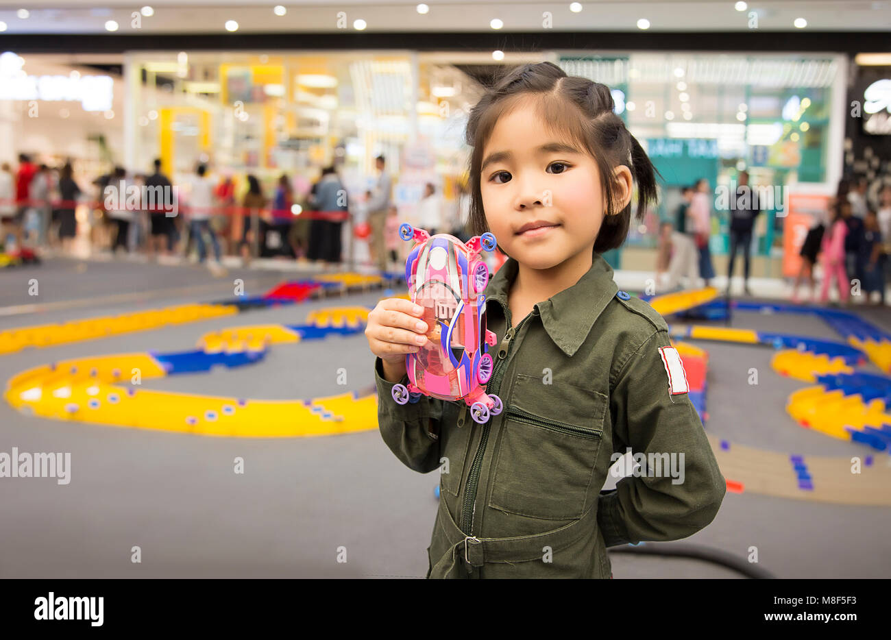 asian girl kid with service suite show model car toy in competition speed racing with boy toy game Stock Photo