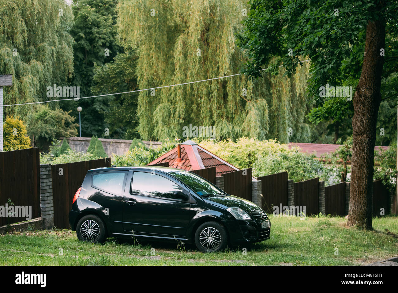 Black Color Citroen C2 Parking Near Private Sector In Summer Time. Stock Photo