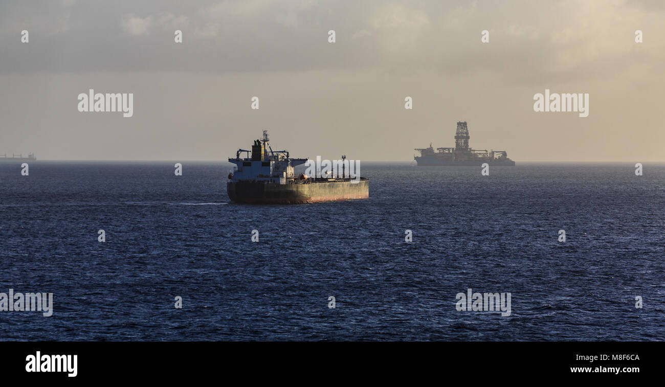 Empty Tanker Sailing Past Oil Rig on Horizon Stock Photo