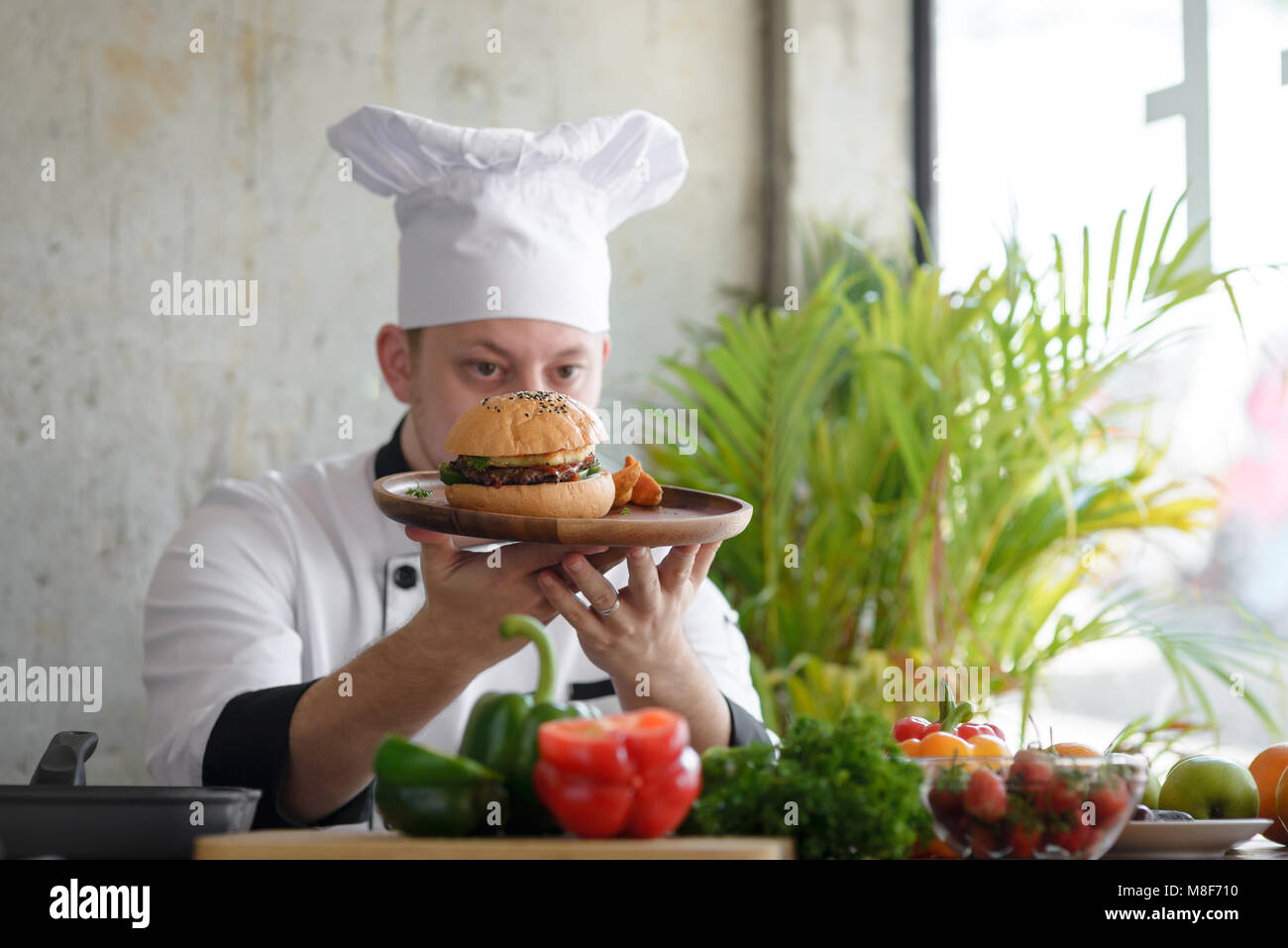 Chef in in a restaurant or hotel kitchen, checking up his food and ...