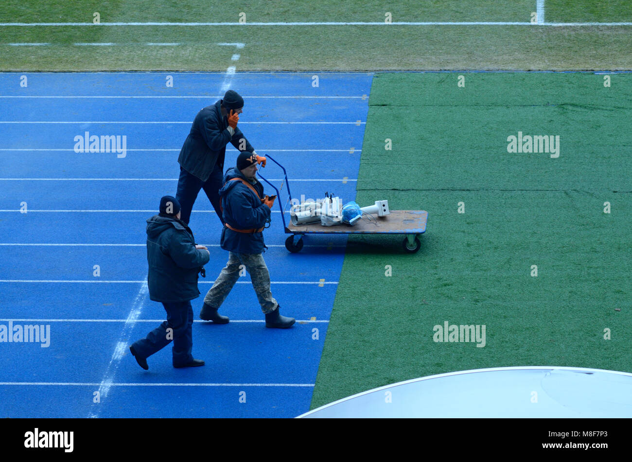 Workers walking on a running track of the Olympic National Sports ...