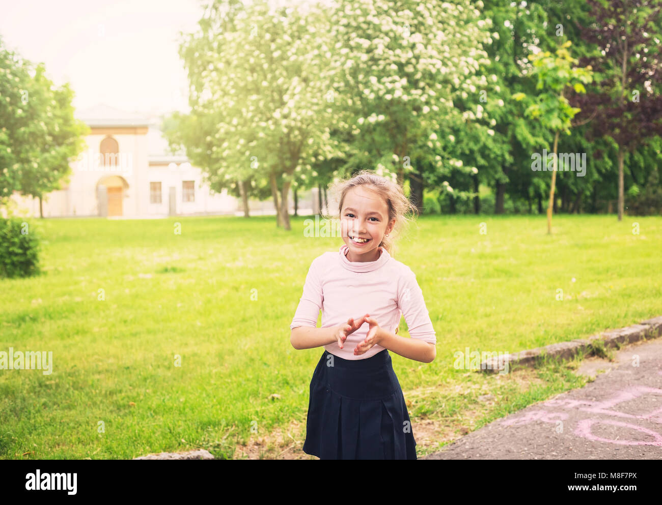Happy preteen girl running on meadow in summer day at sunset Stock Photo