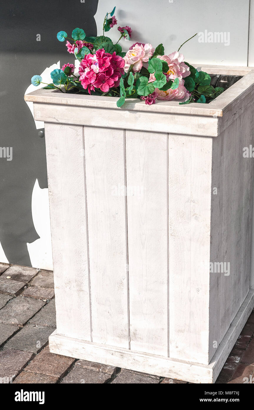 wooden white planter with flowers on top Stock Photo