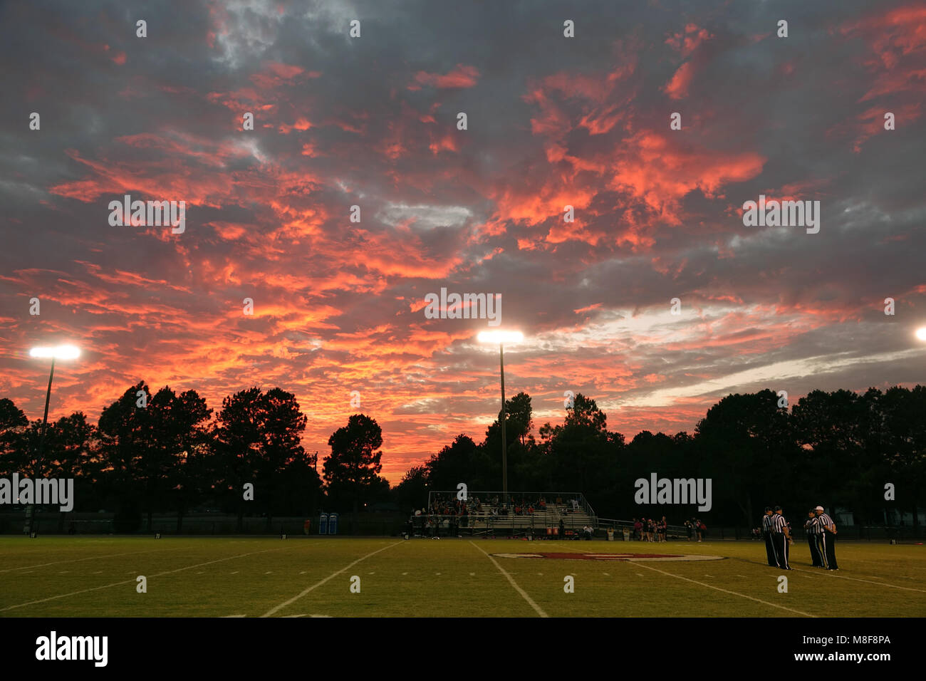 Friday night football at sunset under the stadium lights. Stock Photo