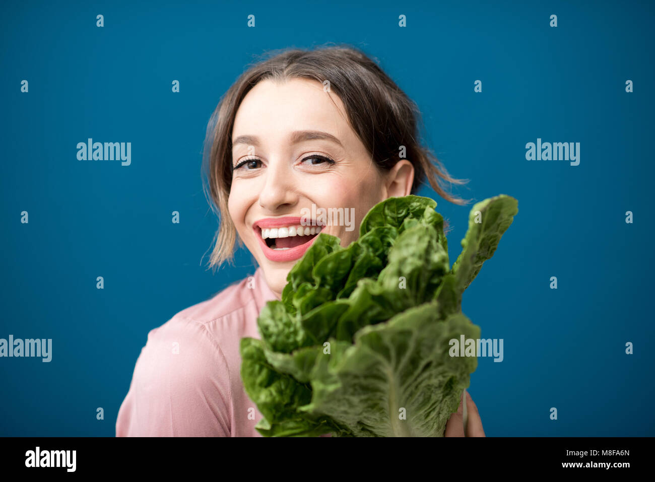 Woman with lettuce on the blue background Stock Photo