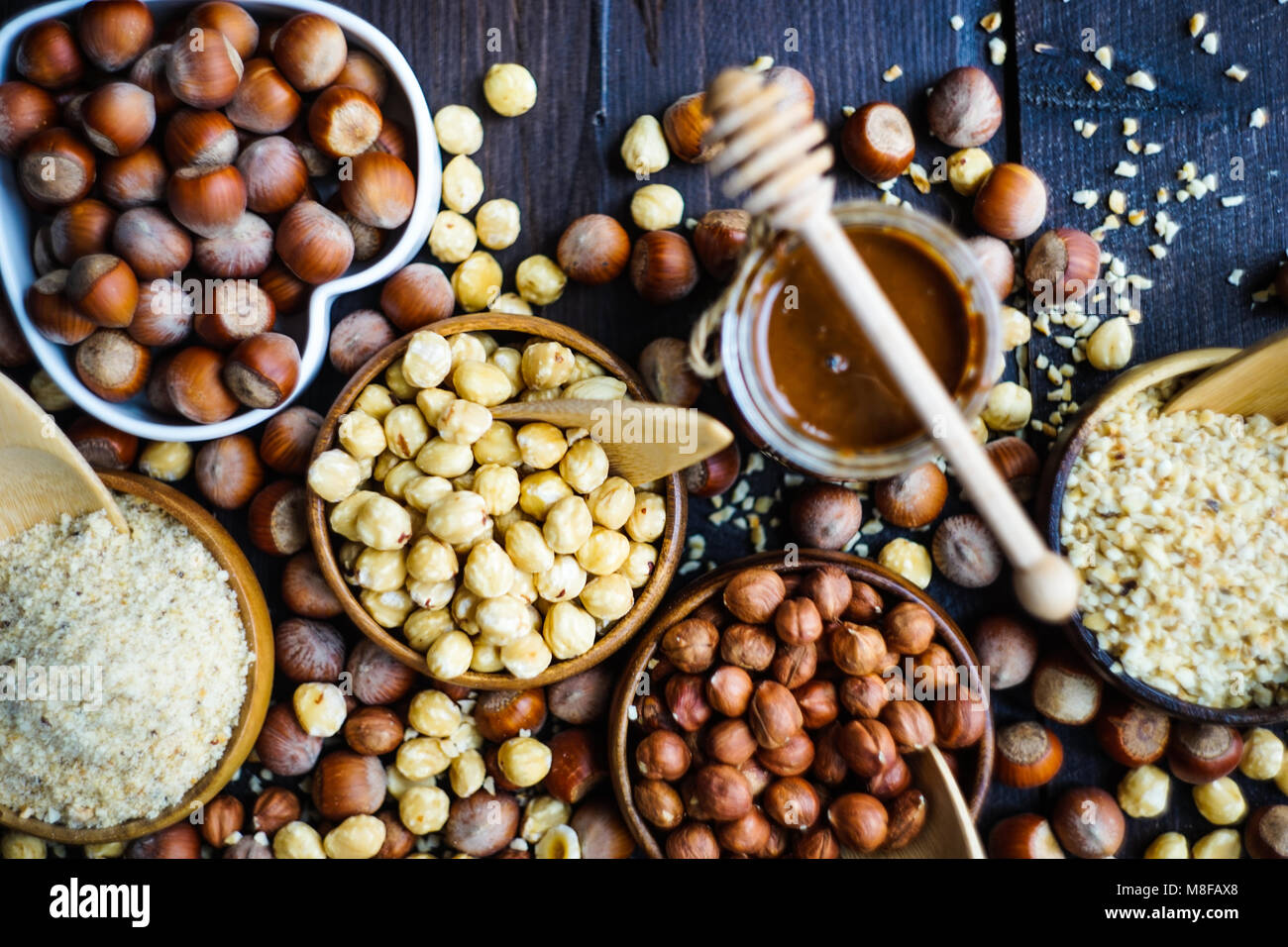 Different types of hazelnuts on dark wooden background with copyspace