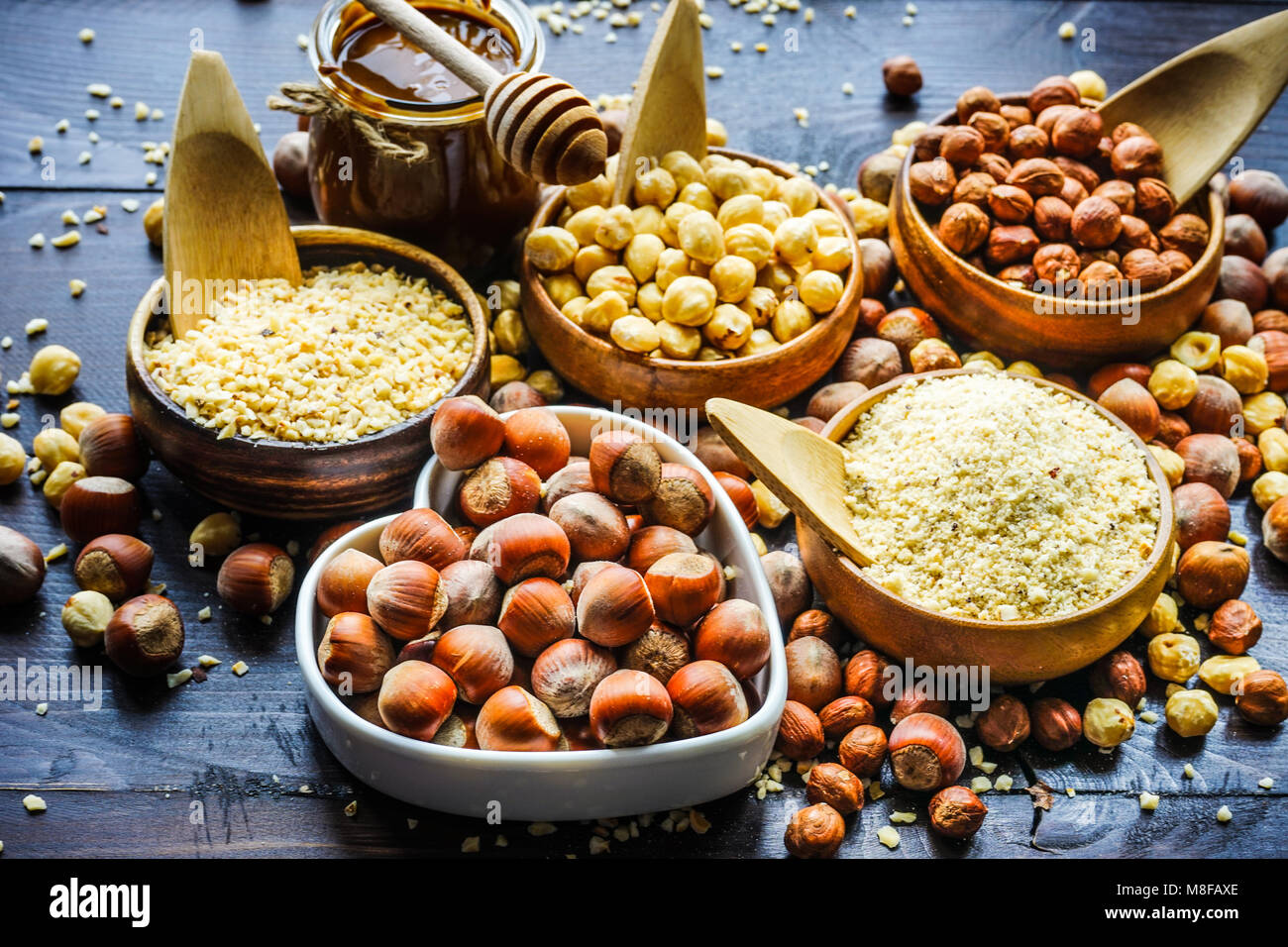 Different types of hazelnuts on dark wooden background with copyspace