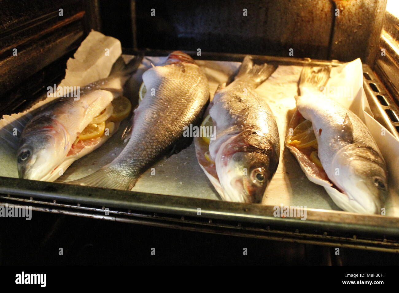 four sea bass cooked in the oven Stock Photo - Alamy