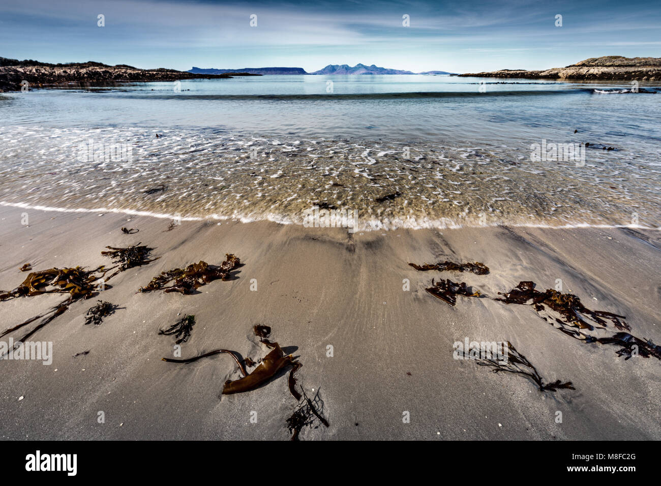 A beautiful picturesque beach at Traigh, Scottish Highlands, with views west towards Eigg and Rum. Stock Photo