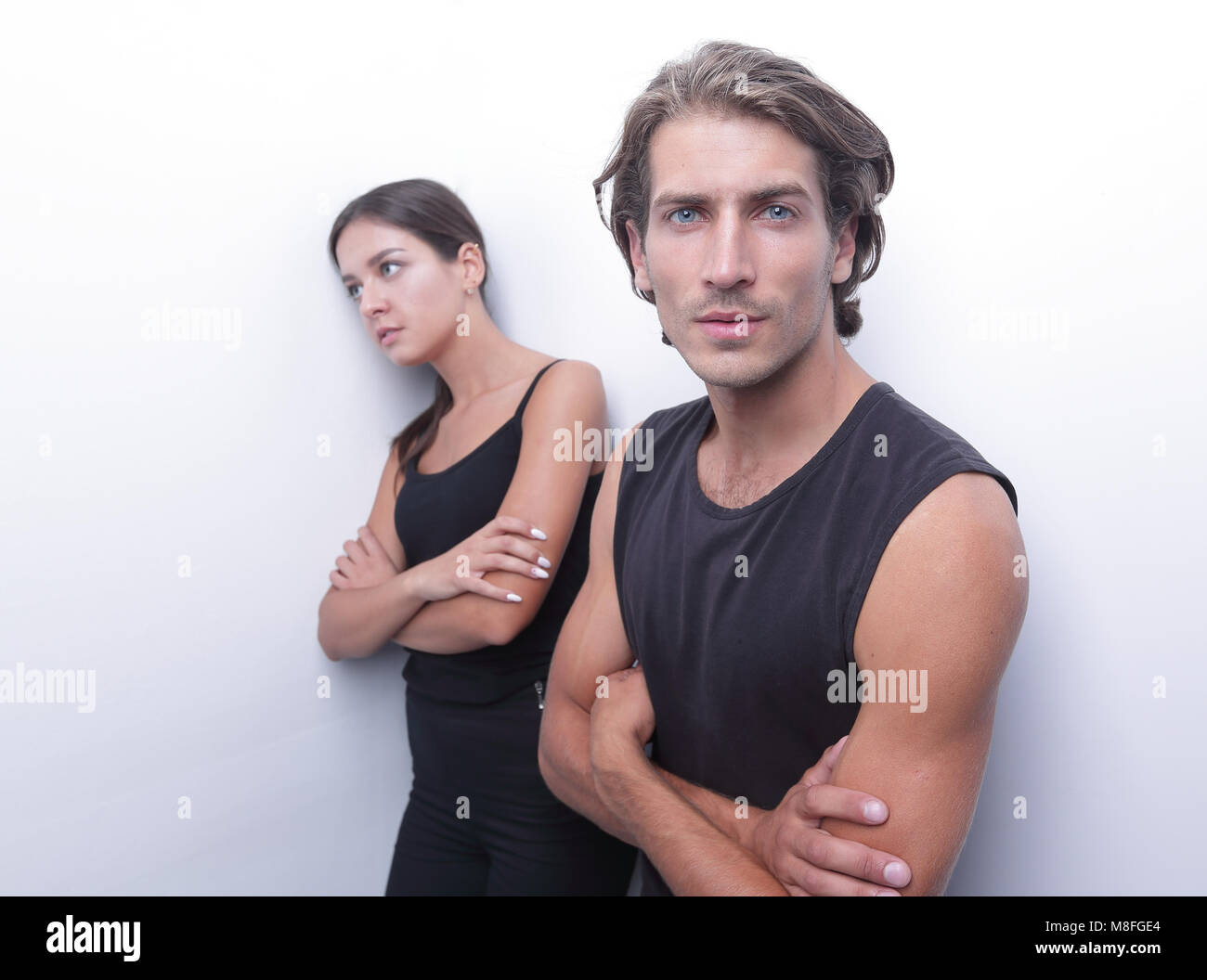 sad couple standing near a white wall Stock Photo - Alamy