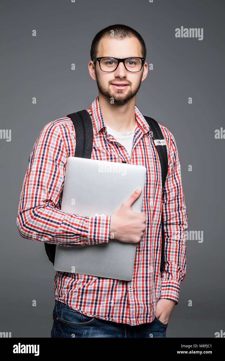 Handsome and young indian Male college student carrying bag on white