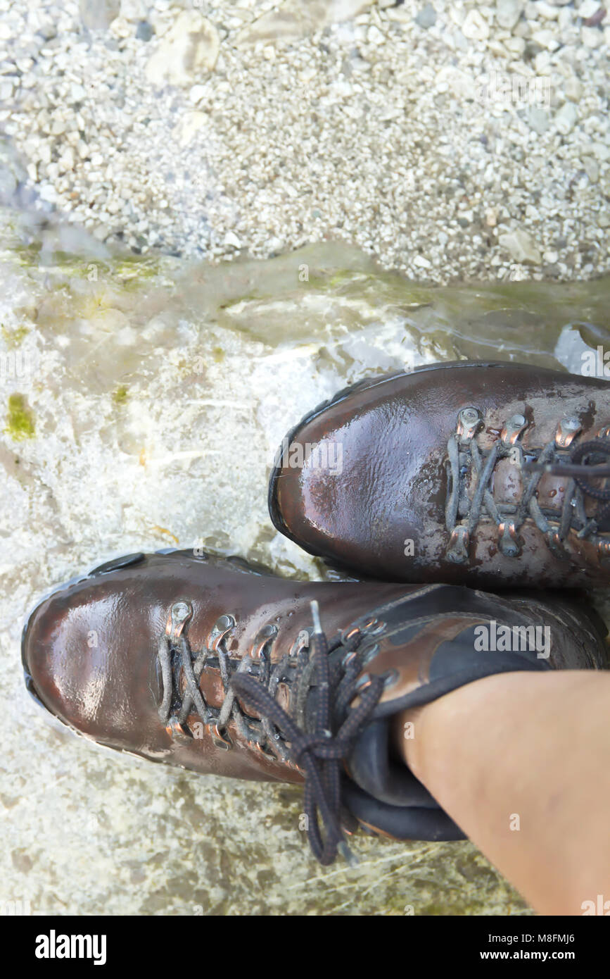 Young Woman Walking on the River with Hiking Boots Stock Photo