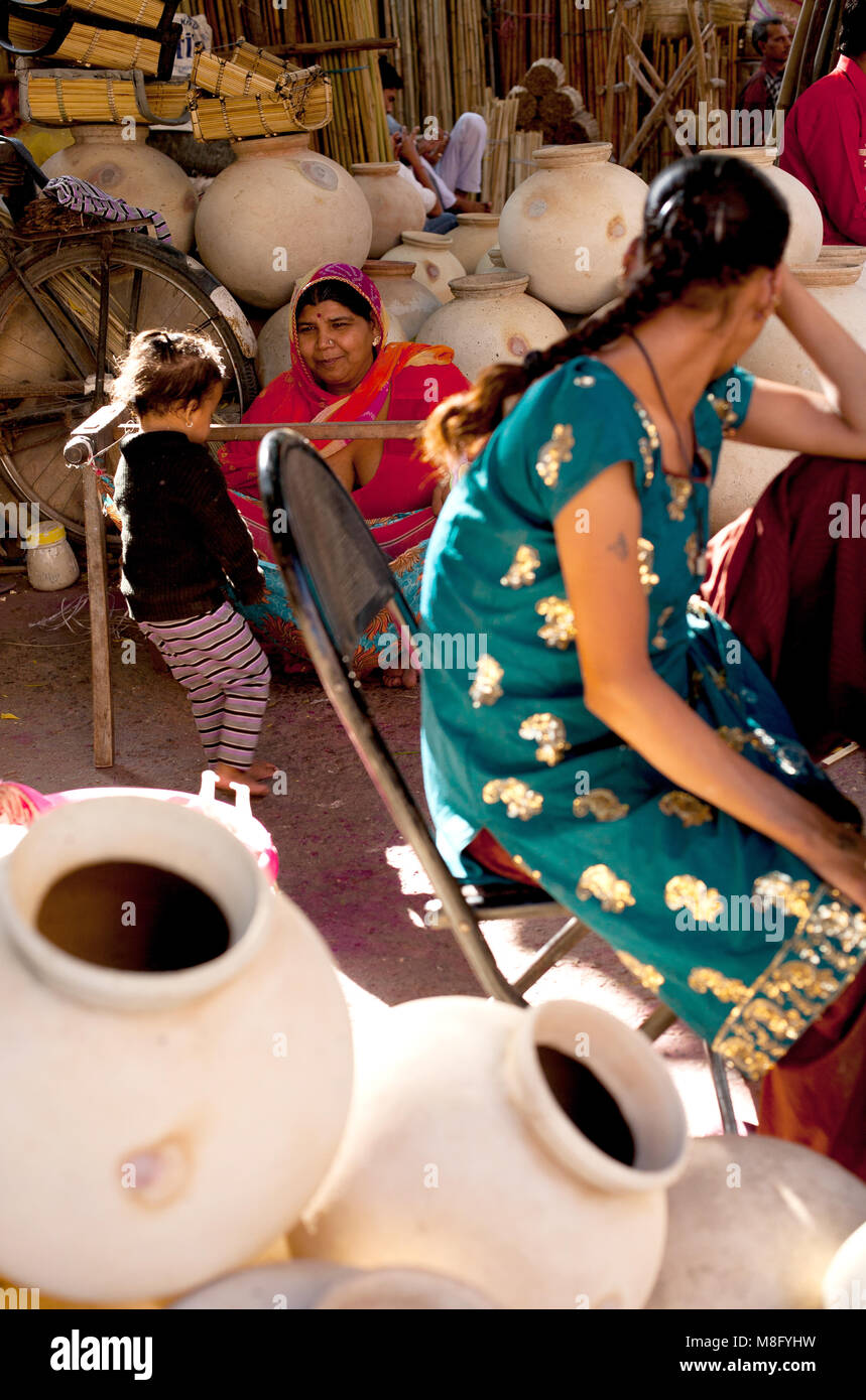Women are selling their handmade products, ceramic pots for carring and storing water and rattan baskets at Indian market in Jodhpur. Women are wearin Stock Photo