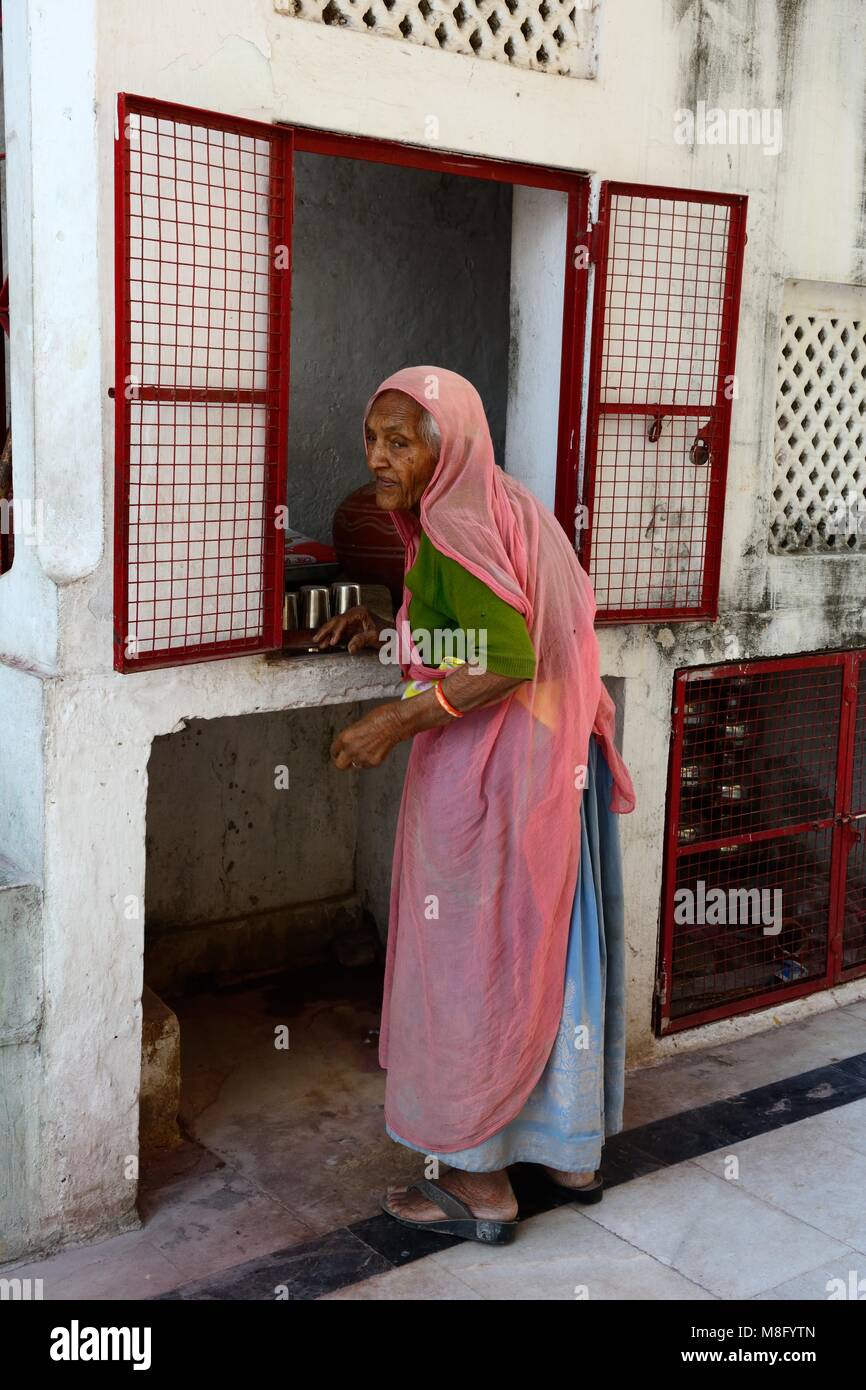Elderly Indian woman working in the jagdish mandir Hindu Temple Udaipur Rajashan India Stock Photo