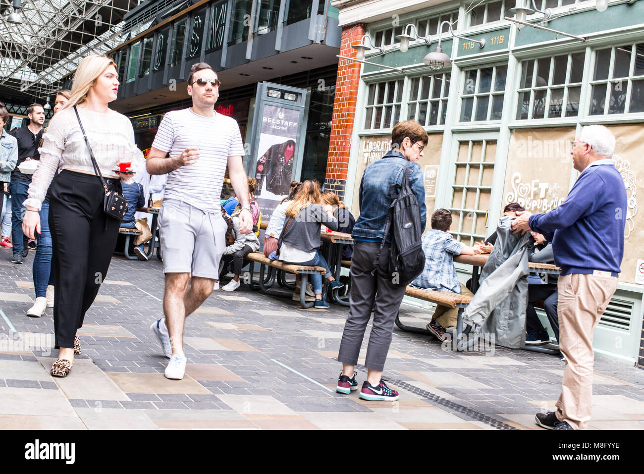 People walking around the cafes and restaurants in Old Spitalfields indoor market. Spitalfields, East London, UK Stock Photo