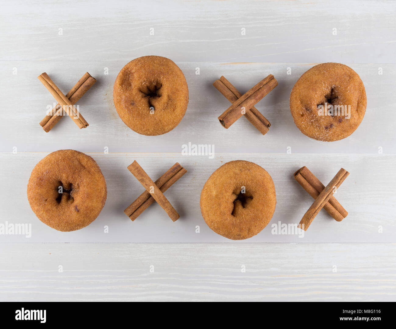 Grid of Cinnamon Xs and Donut Os on Light Wooden Table Stock Photo
