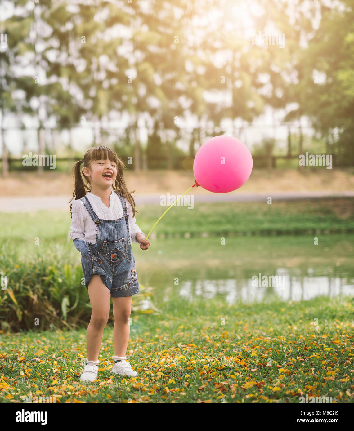 portrait happy little girl with balloon walks in the park outdoors ...