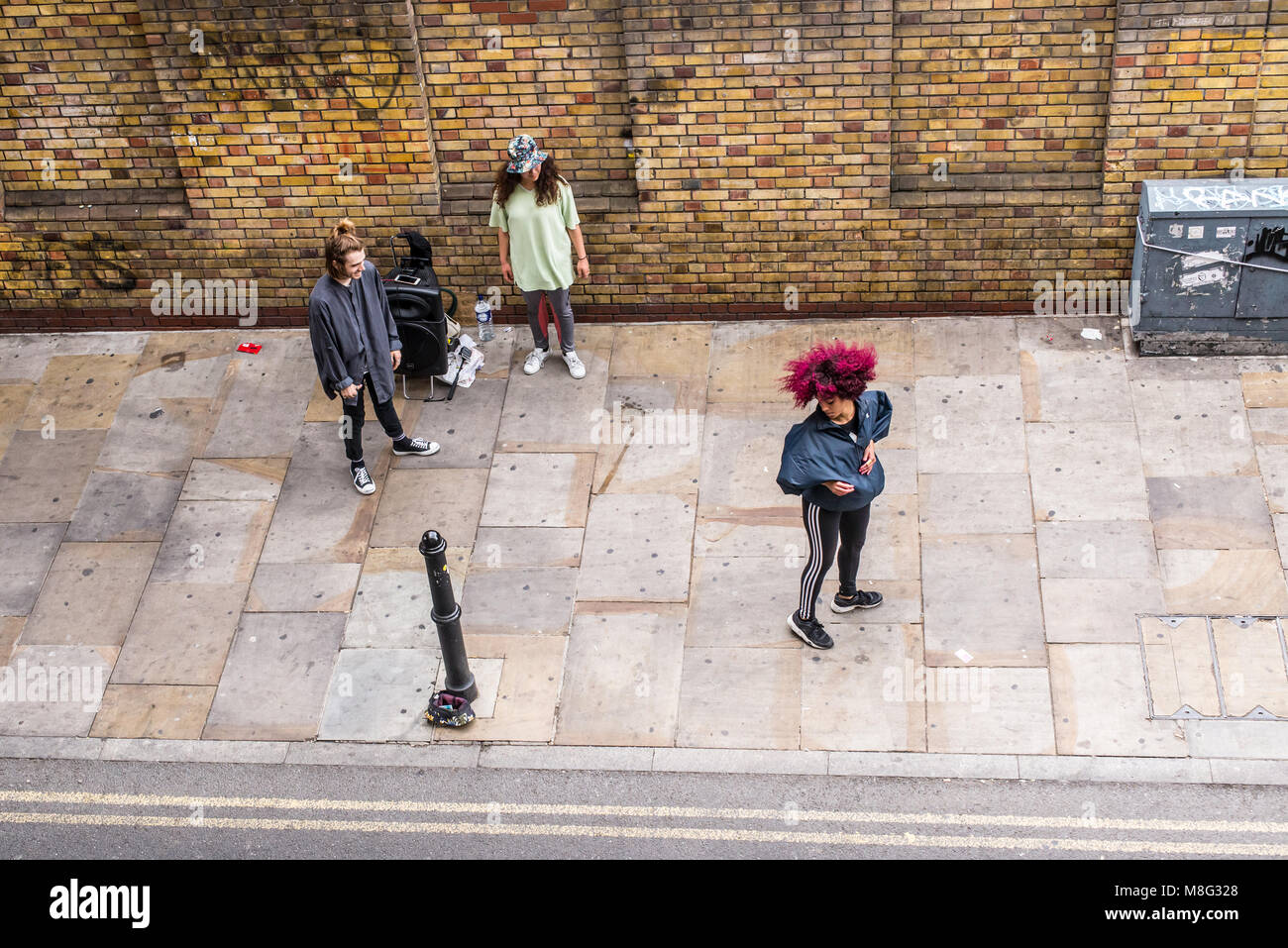 Street dance improvised performance by hip-hop acrobatic dancers outside The Old Truman Brewery, Ely's Yard, Shoreditch, London, UK Stock Photo