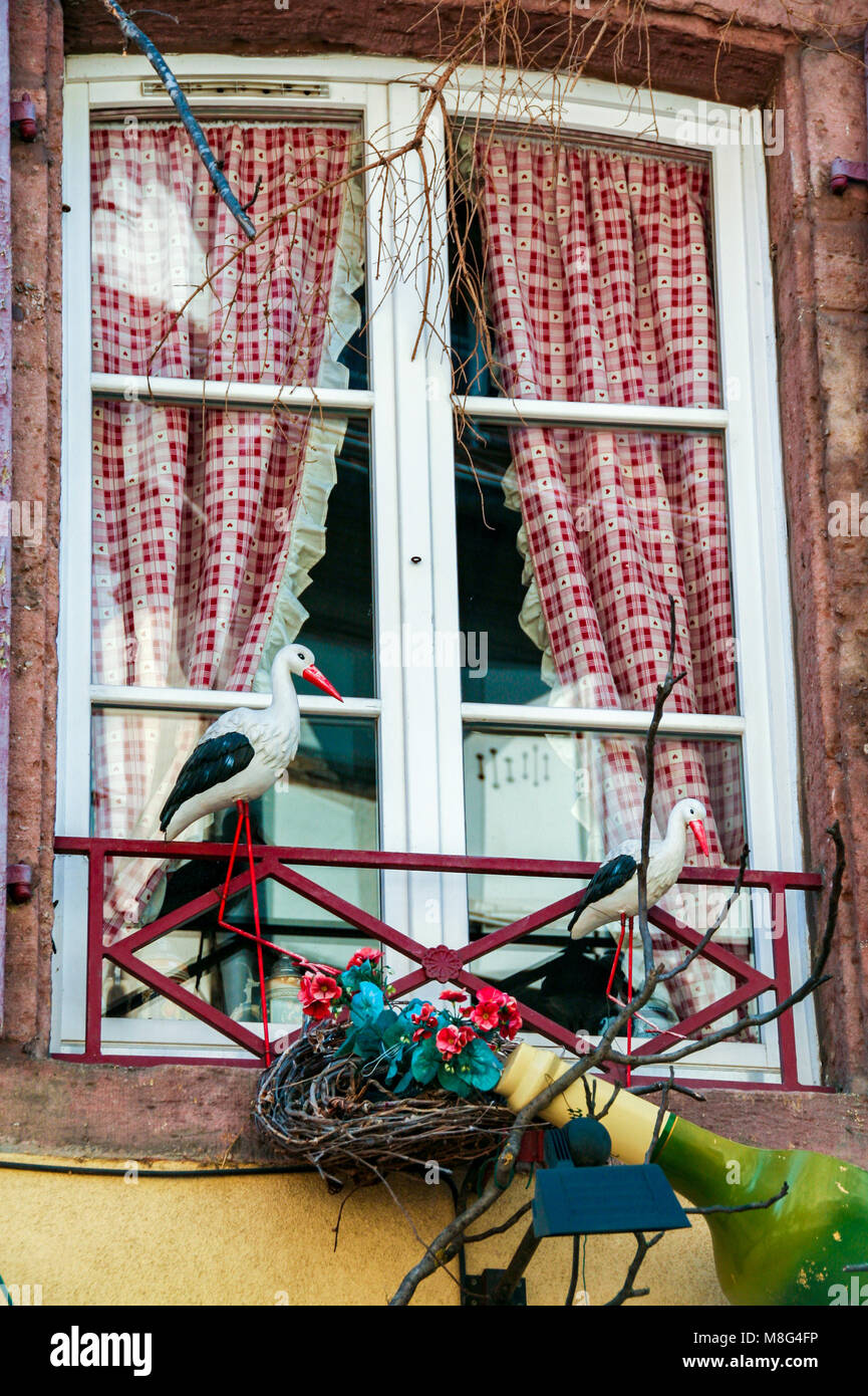 country chic window with red curtains and storks in Colmar, Alsace