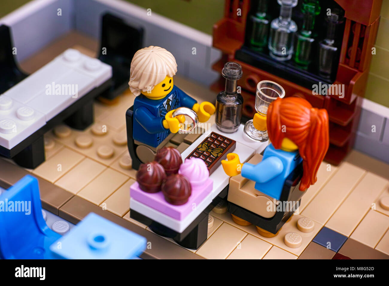 Tambov, Russian Federation - January 04, 2018 Lego couple sitting at the table in Restaurant. Man gets ready to propose with the ring. Studio shot. Stock Photo