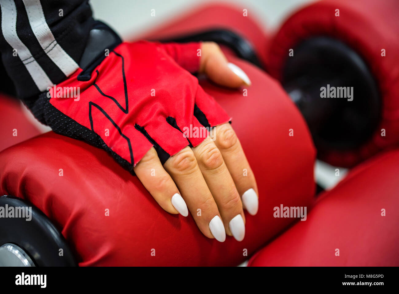 Woman's hand touches gym machine Stock Photo