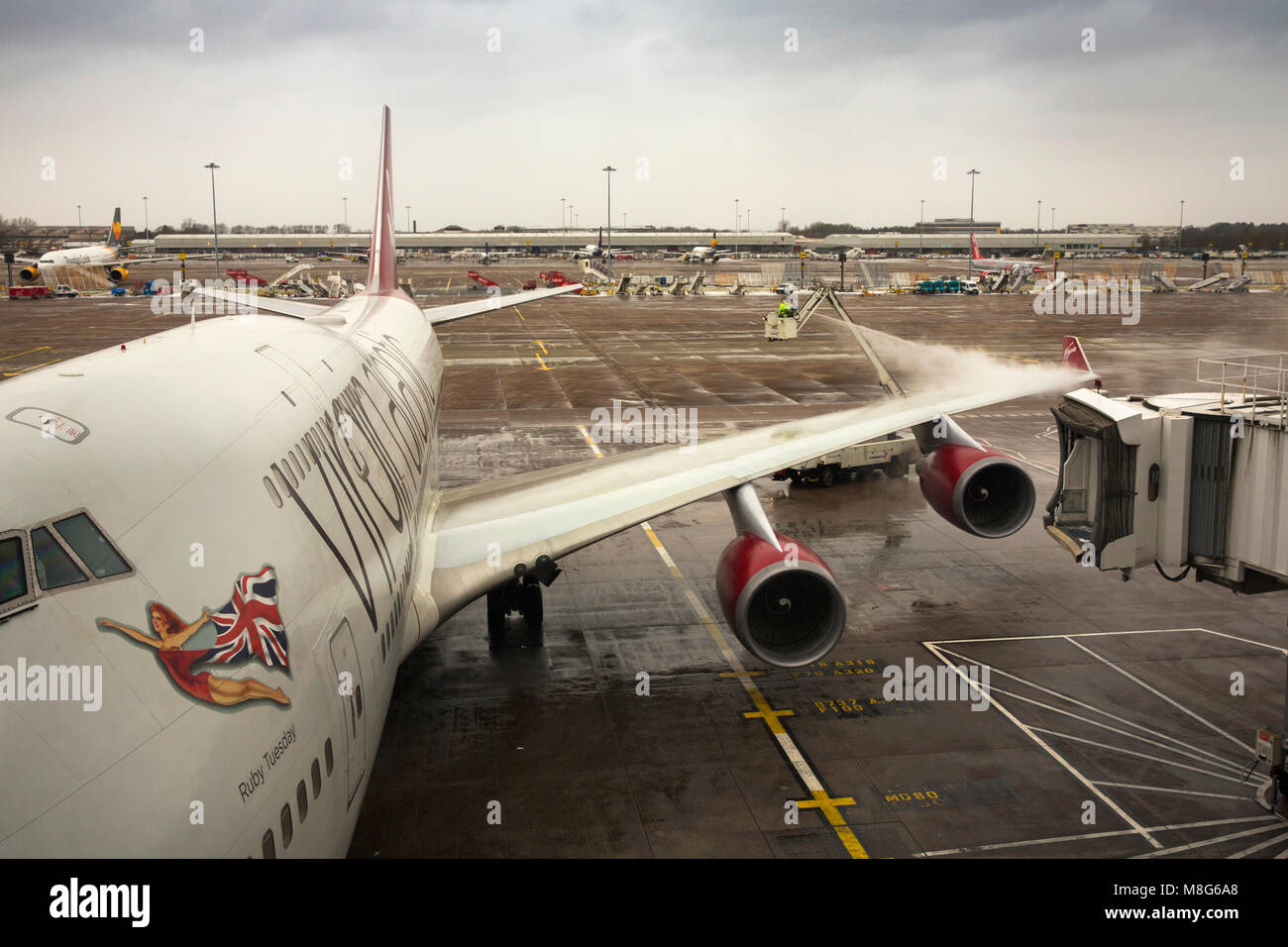 UK, England, Manchester Airport, workers de-icing Virgin Atlantic Boeing 747-41R aircraft in extremely cold winter weather Stock Photo