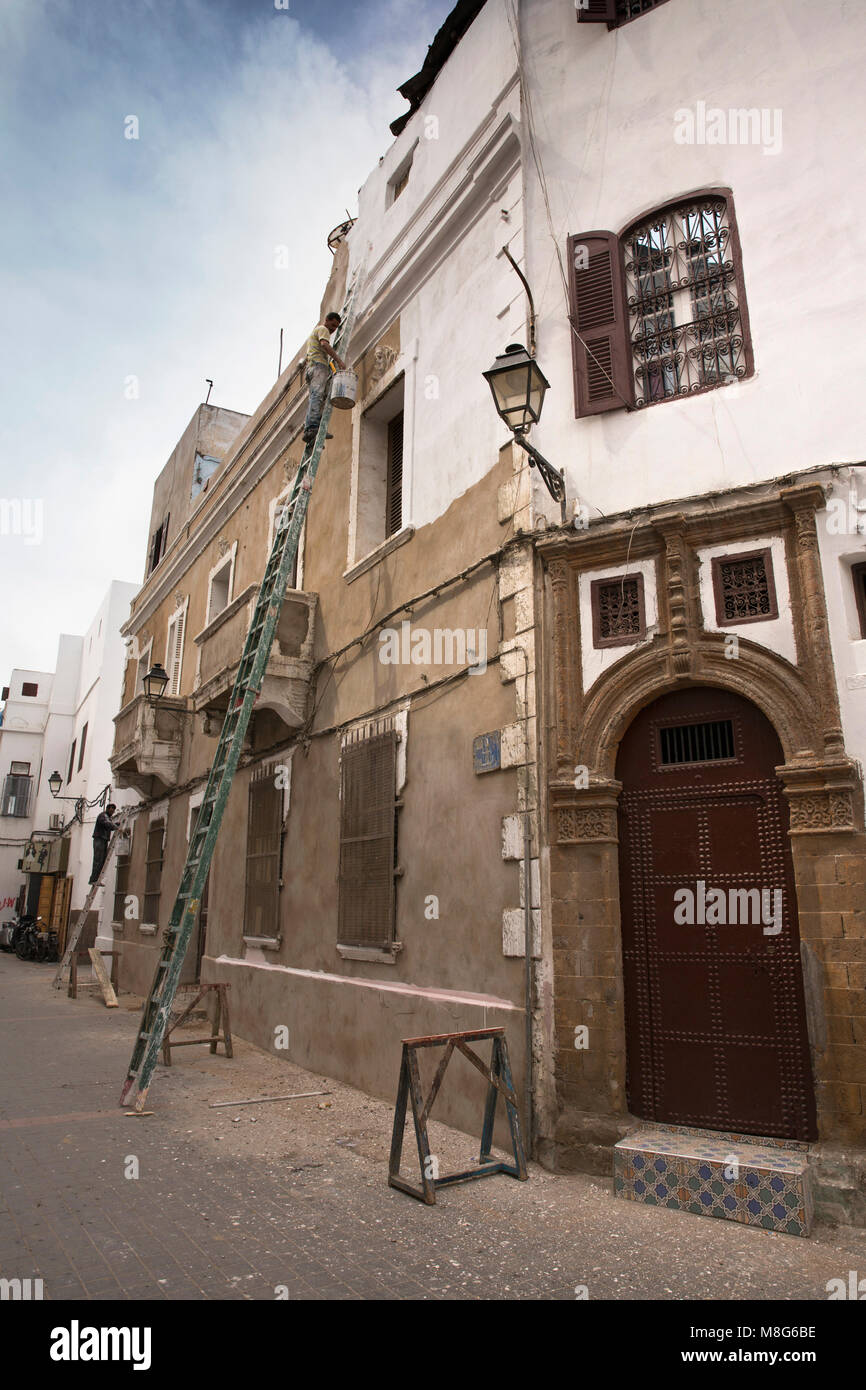 Morocco, Casablanca, Medina, men up very long ladders painting building white Stock Photo