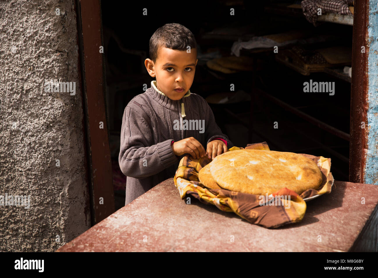 Morocco, Casablanca, Medina, Rue Tnaker, boy eating freshly baked loaf of bread Stock Photo