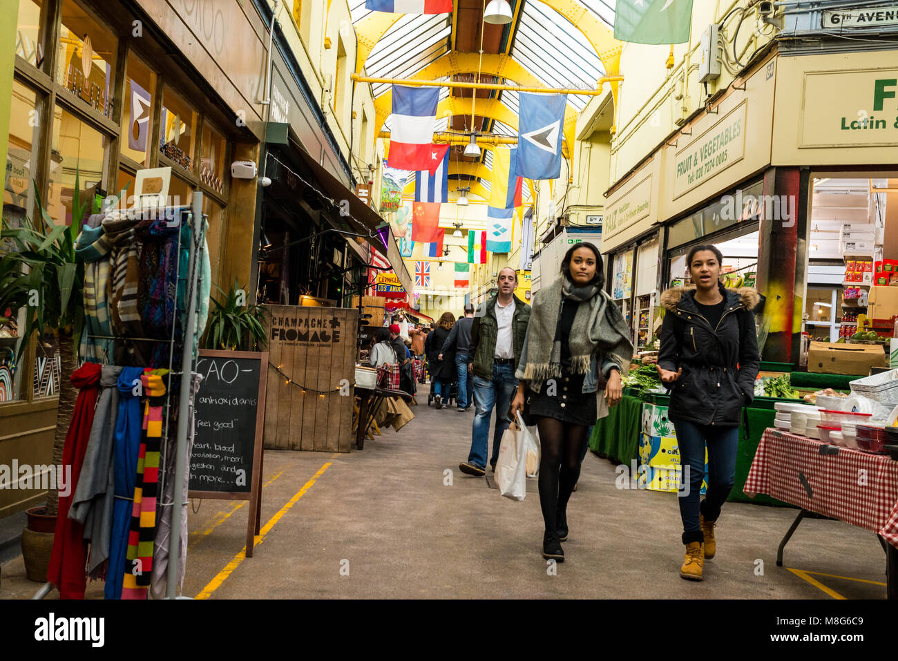 People shopping in the indoor Brixton Village Market, a multicultural community market with independent shops and ethnic restaurants in South London. Stock Photo