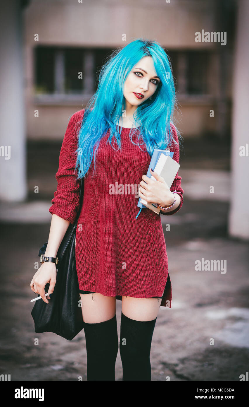 Portrait of cute smiling blue-haired grunge (rock) girl with books and  cigarette in hands Stock Photo - Alamy