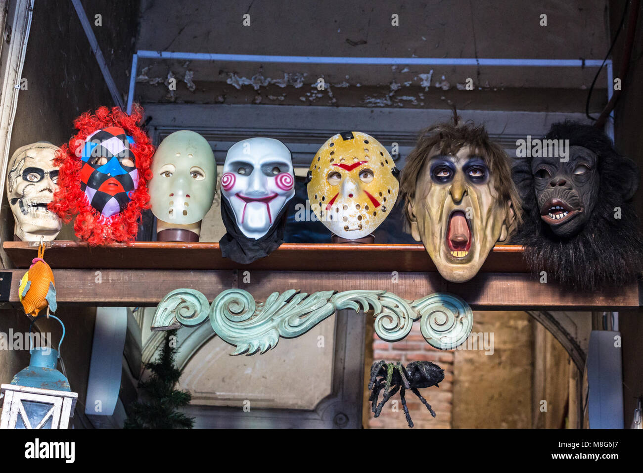 Group of theatrical mask placed on the wall and a wooden stand in Montevideo, Uruguay. Stock Photo