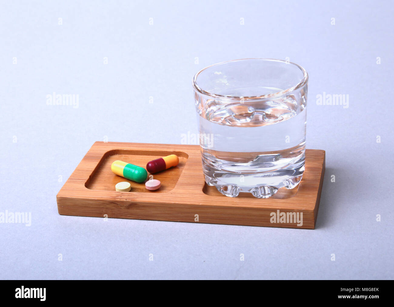Glass of water and pills on white background Stock Photo