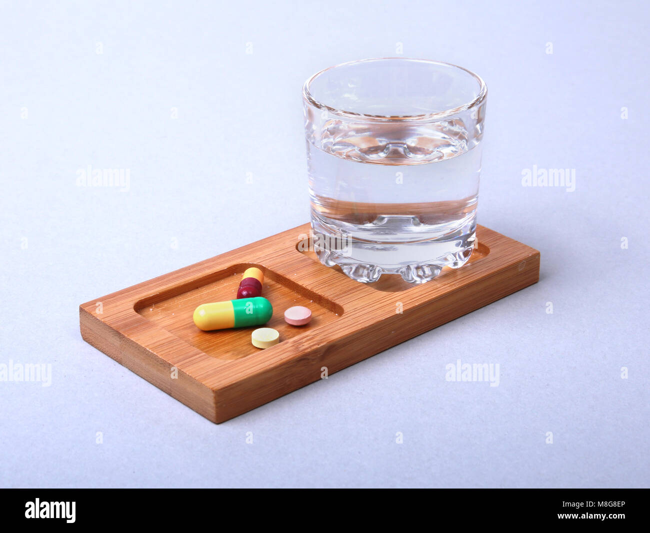 Glass of water and pills on white background Stock Photo