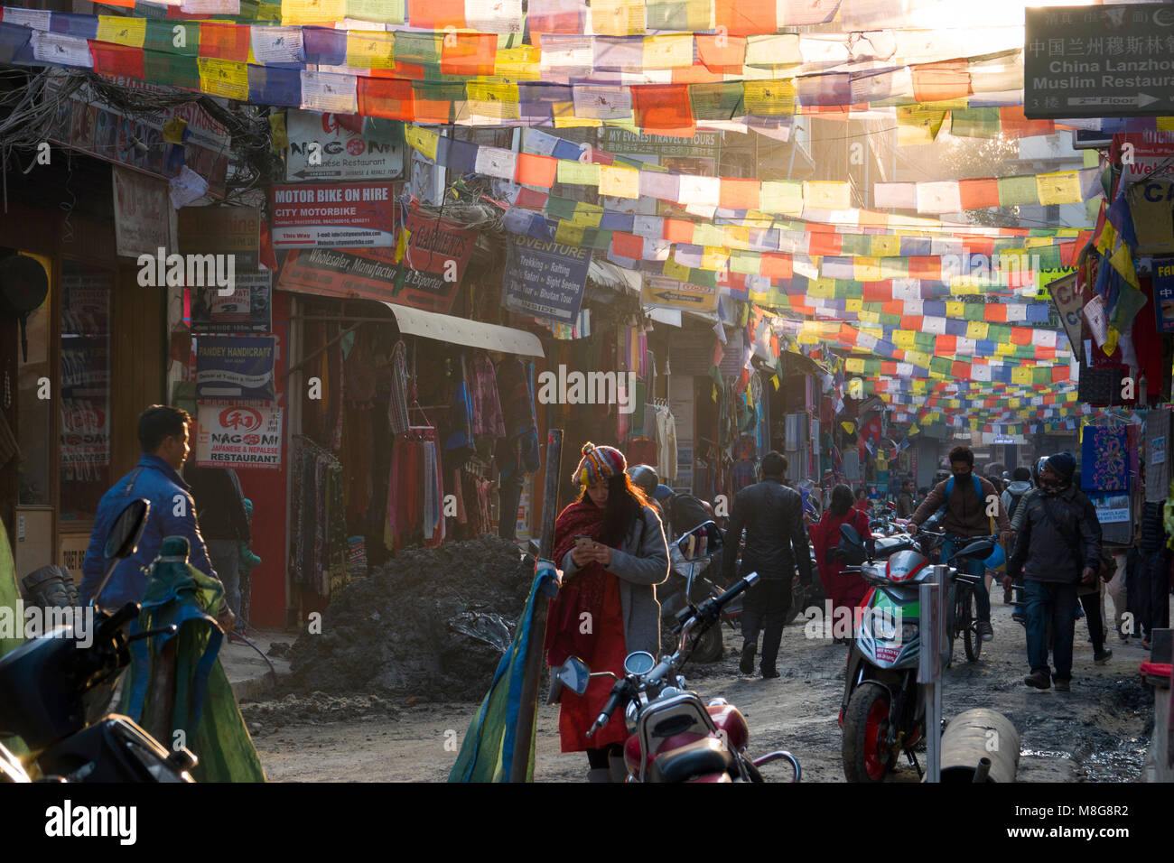 Prayer flags hanging over street with people walking in Thamel, Kathmandu, Nepal Stock Photo