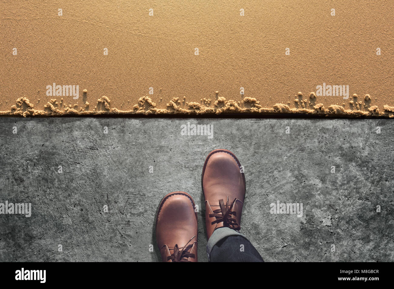 Comfort Zone Concept, Male with Leather Shoes Steps from Cement Floor into Sand Beach. Top View Stock Photo