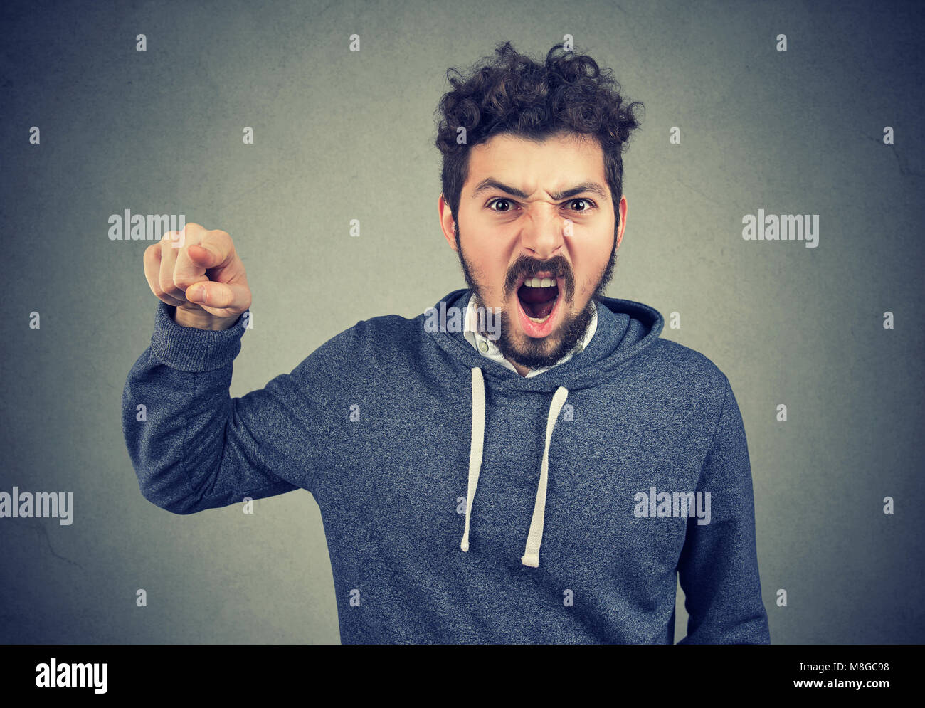 Angry young man accusing someone screaming Stock Photo