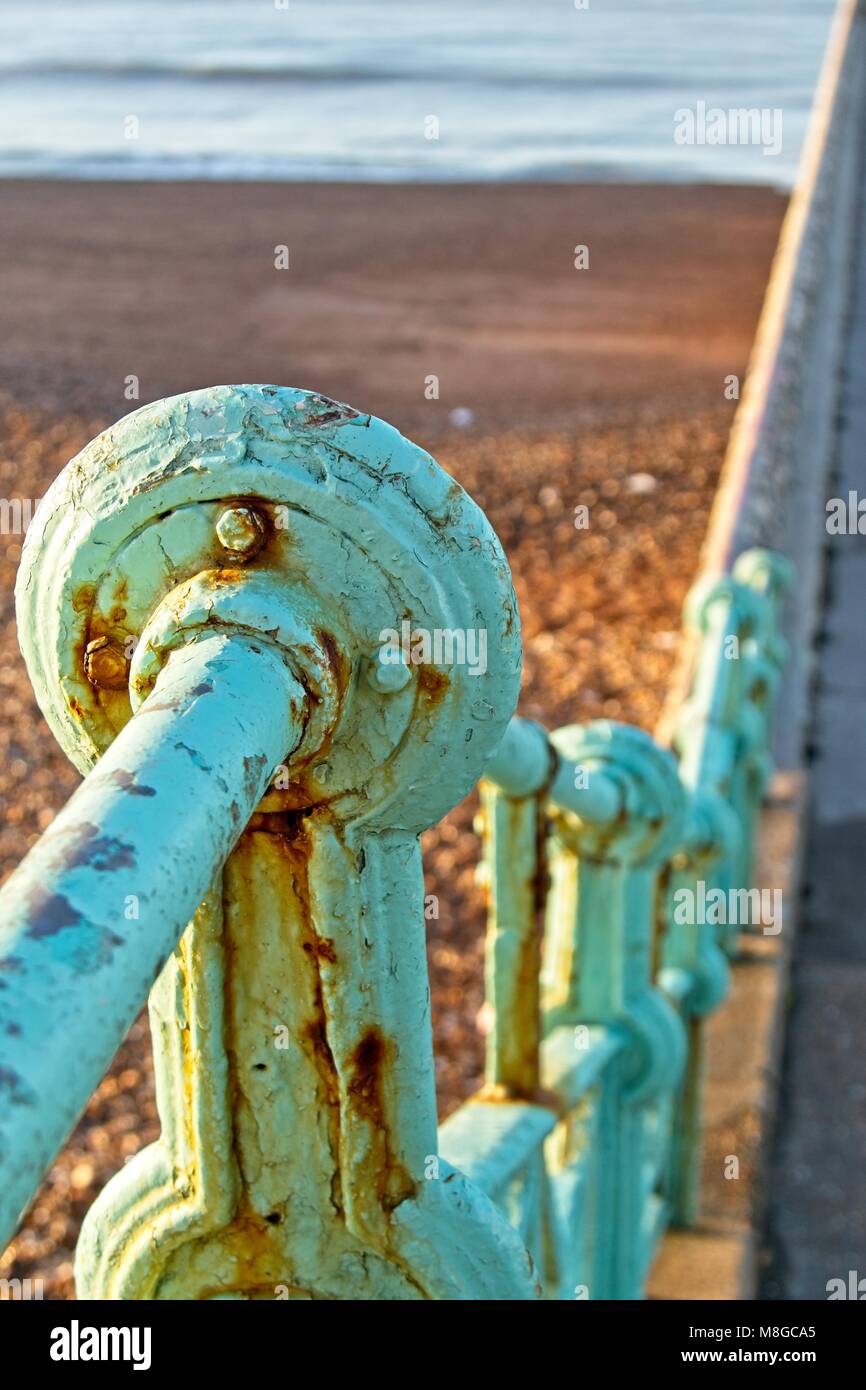 Green railings with rust and peeling paint at beach in Brighton Sussex