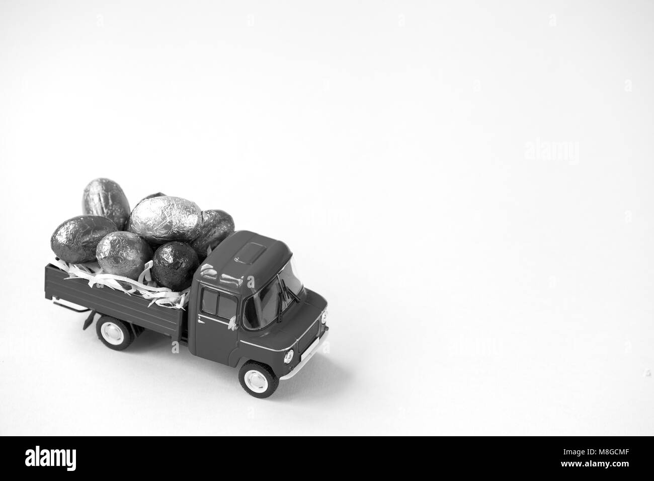 Green pickup toy carrying Easter Egg chocolates. Stock Photo