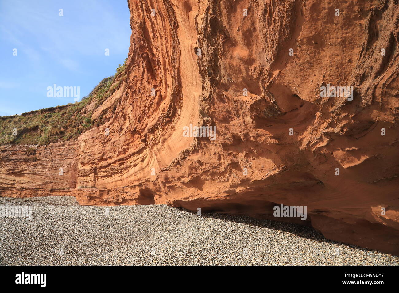 Red sand stone cliffs on the pebble beach in Ladram Bay in East Devon Stock Photo