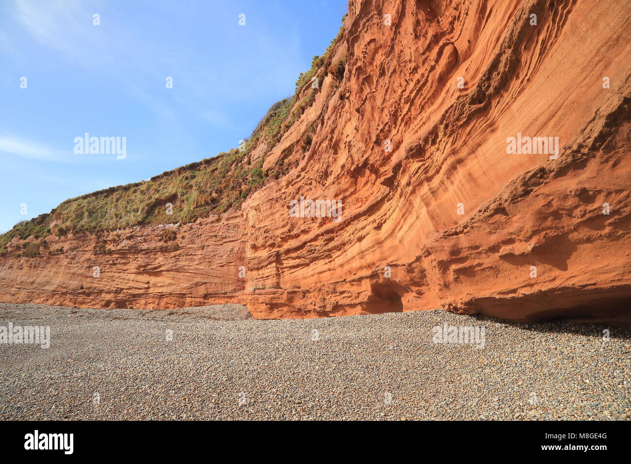 Red sand stone cliffs on the pebble beach in Ladram Bay in East Devon Stock Photo