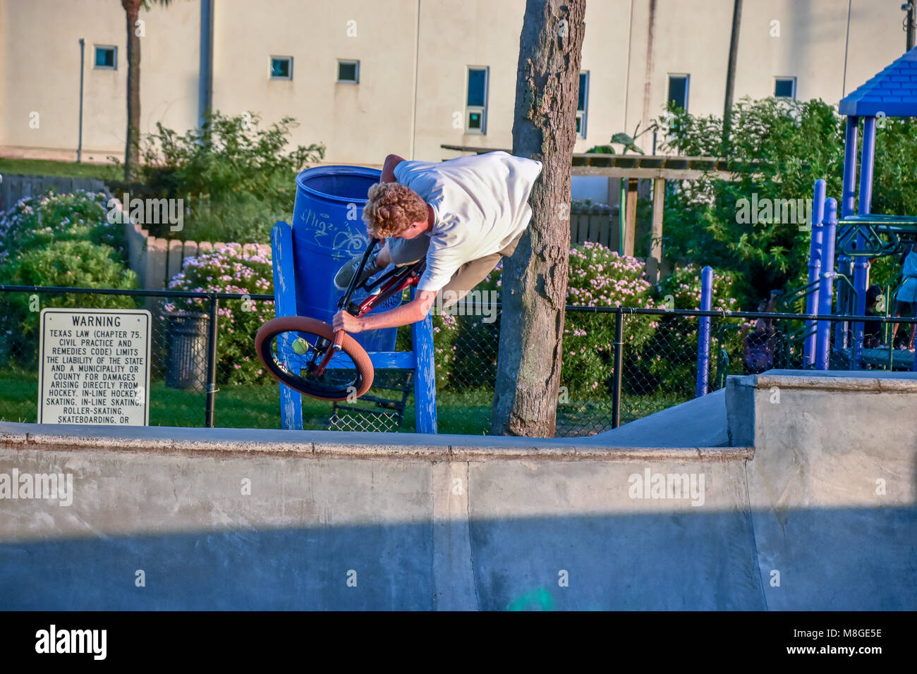 Teenage boys on their BMX bicycles practicing jumps at a skateboard park in Galveston Texas. Stock Photo