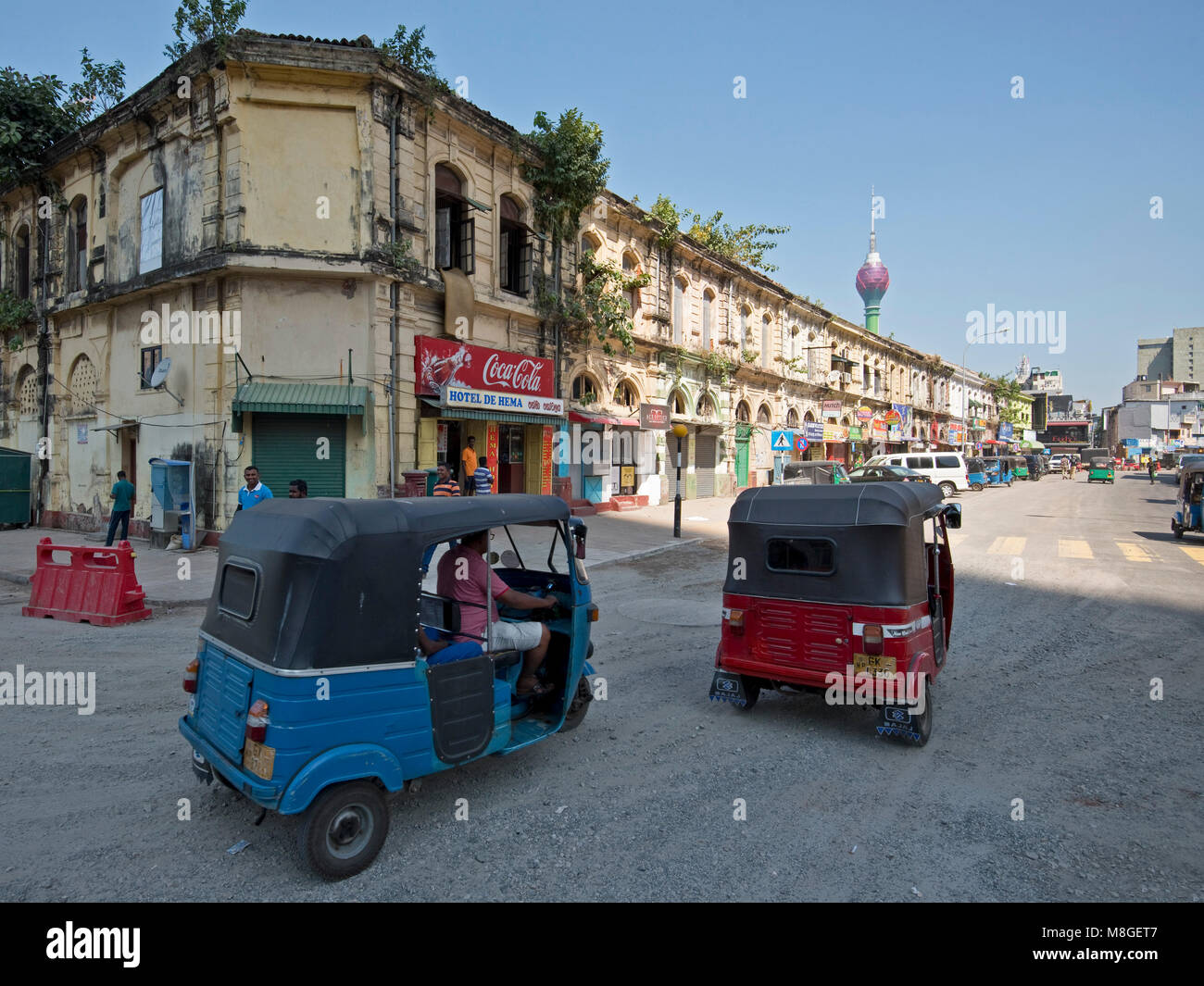 Typical street scene in the Fort area of Colombo know for its colonial buildings on a sunny day with blue sky and tuk tuks. Stock Photo