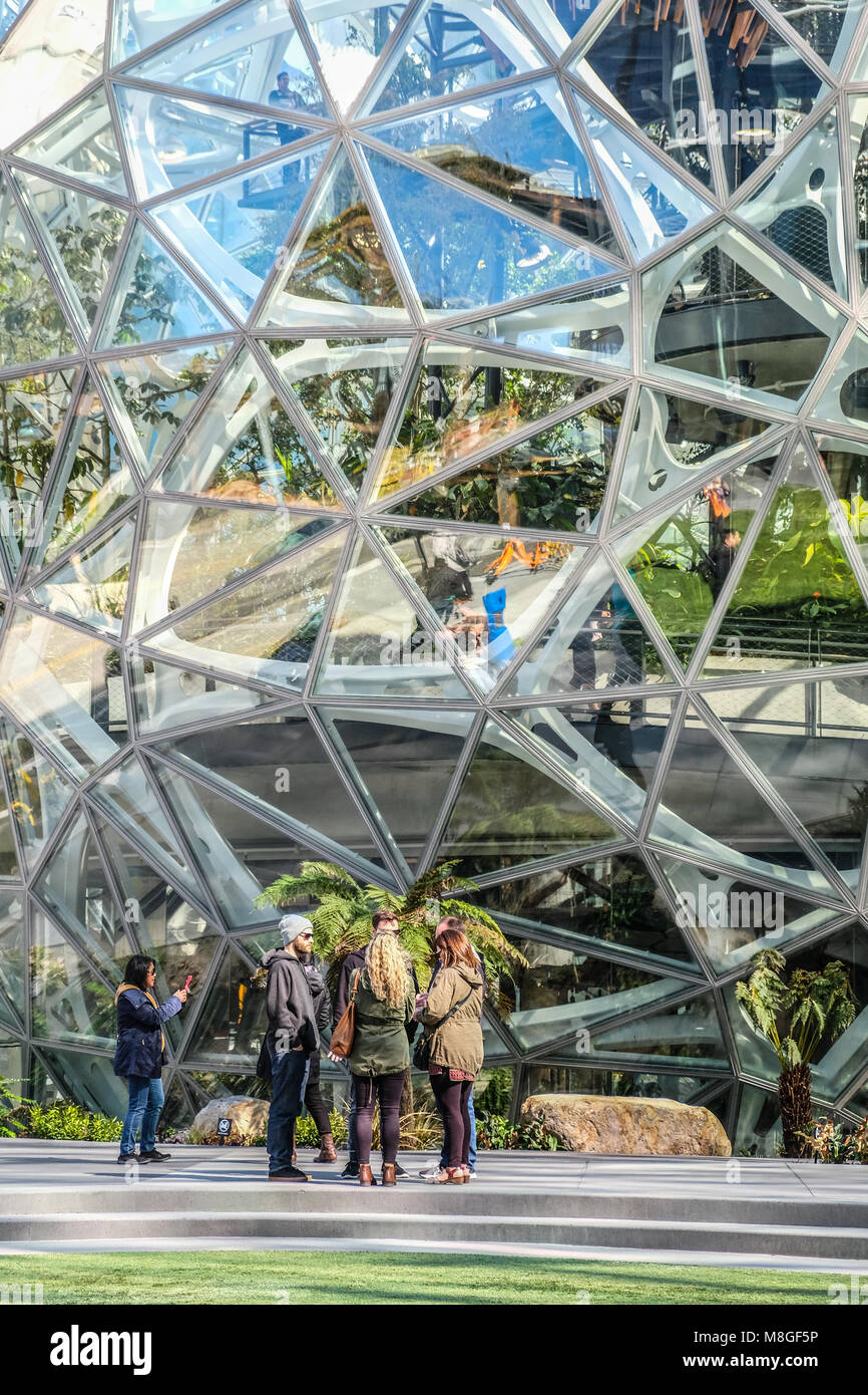 People chat in front of the glass dome Spheres at Amazon headquarter in