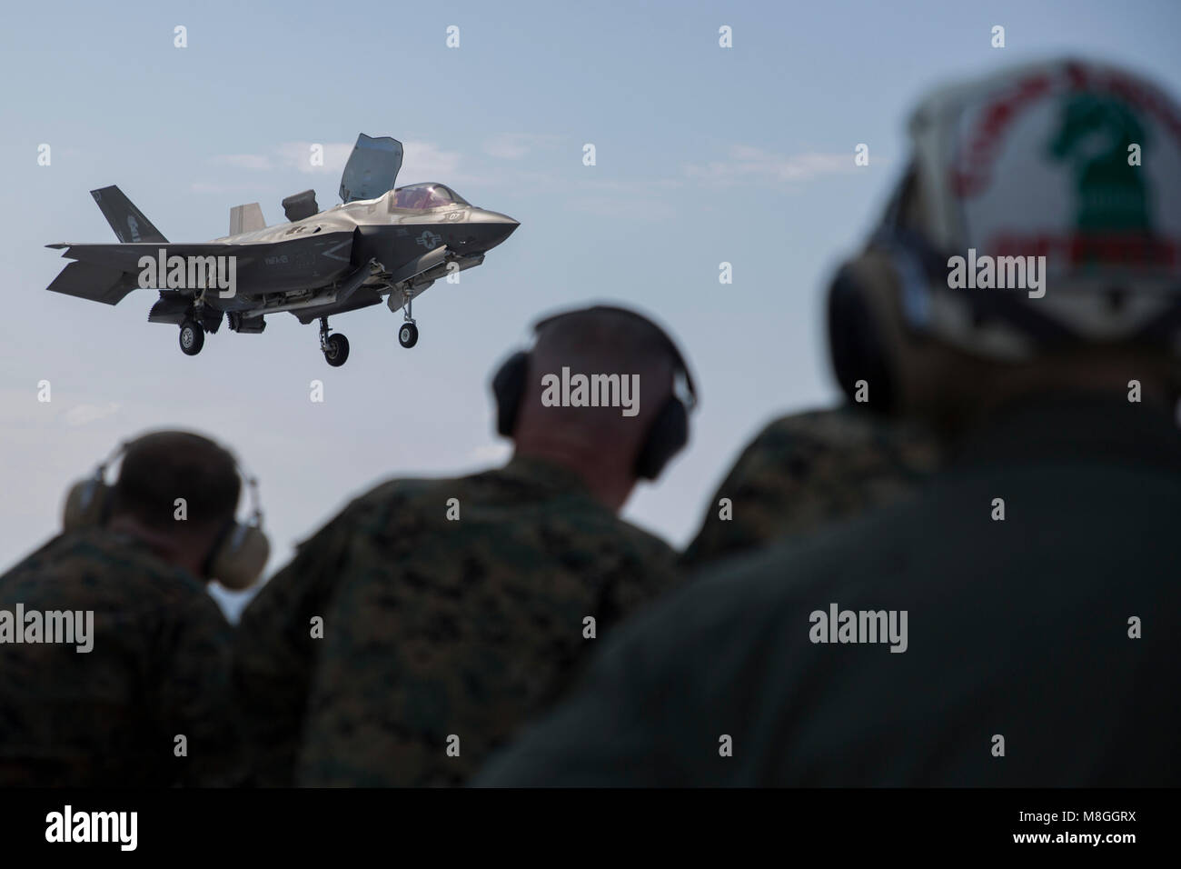 The III Marine Expeditionary Force Commanding General Lt. Gen. Lawrence D. Nicholson (center) observes an F-35B Lightning II during flight operations on the USS Wasp (LHD 1), March 12, 2018. The 31st Marine Expeditionary Unit is preparing for its regularly scheduled Spring Patrol 2018 in support of stability and security in the Indo-Pacific region. As the Marine Corps' only continuously forward-deployed MEU, the 31st MEU provides a flexible force ready to perform a wide range of military operations. (U.S. Marine Corps photo by Cpl. Bernadette Wildes) Stock Photo
